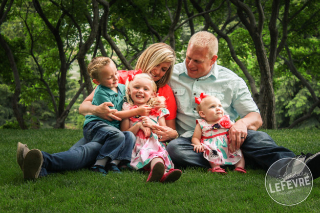 Lindsey LeFevre Photography. Family sitting on the grass tickling each other.